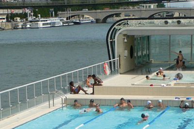 Piscine en plein air flottant sur la Seine avec solarium et transats